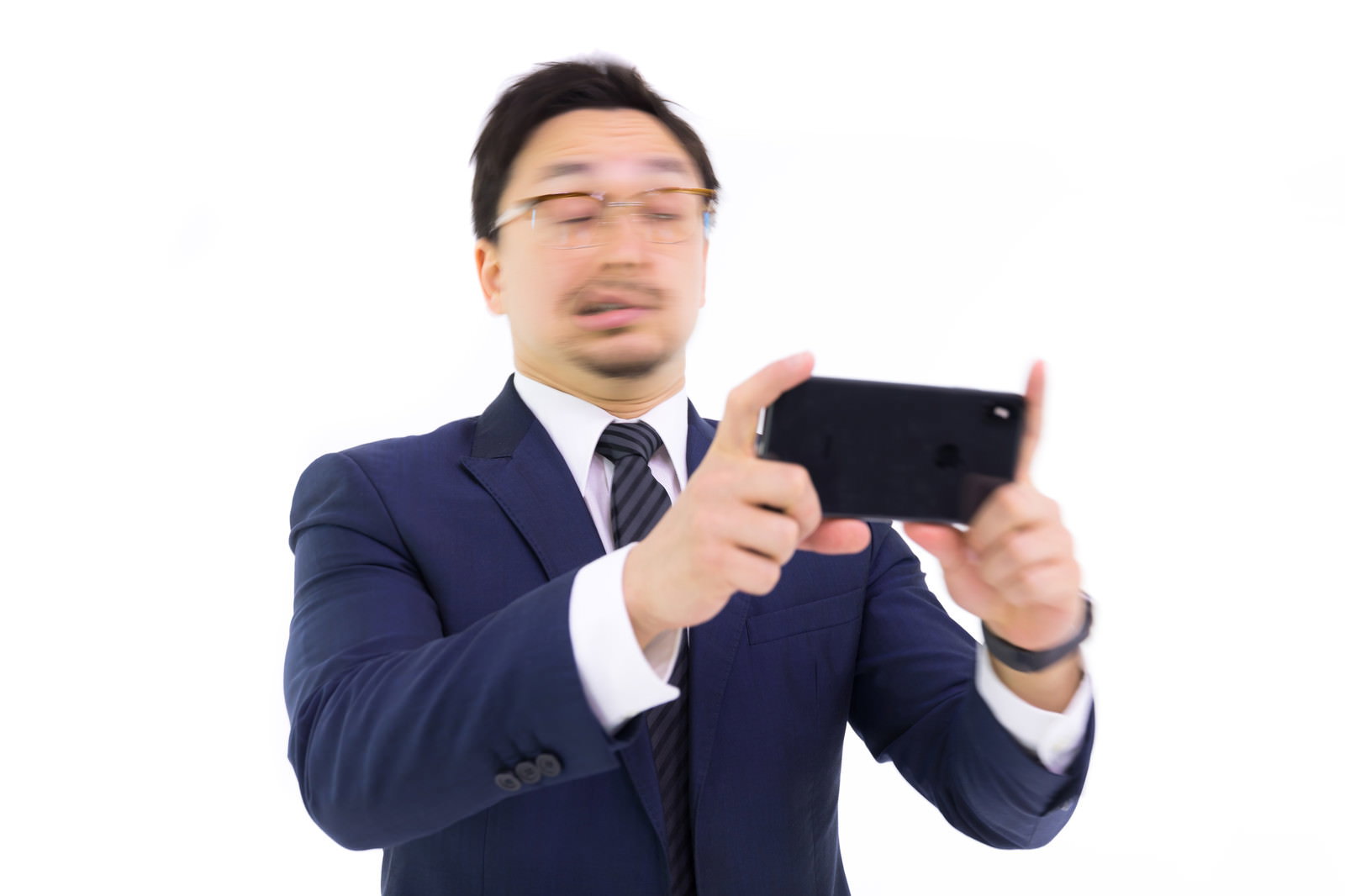 スーツ姿の男性がスマートフォンを横向きに両手で持ち画面を見ている［モデル：Max_Ezaki］