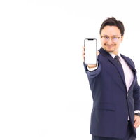 iPhoneの画面を差し出すスーツ姿のビジネスマンの写真