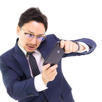 顔認証がされなくてイライラが増す外国人ビジネスマンの写真