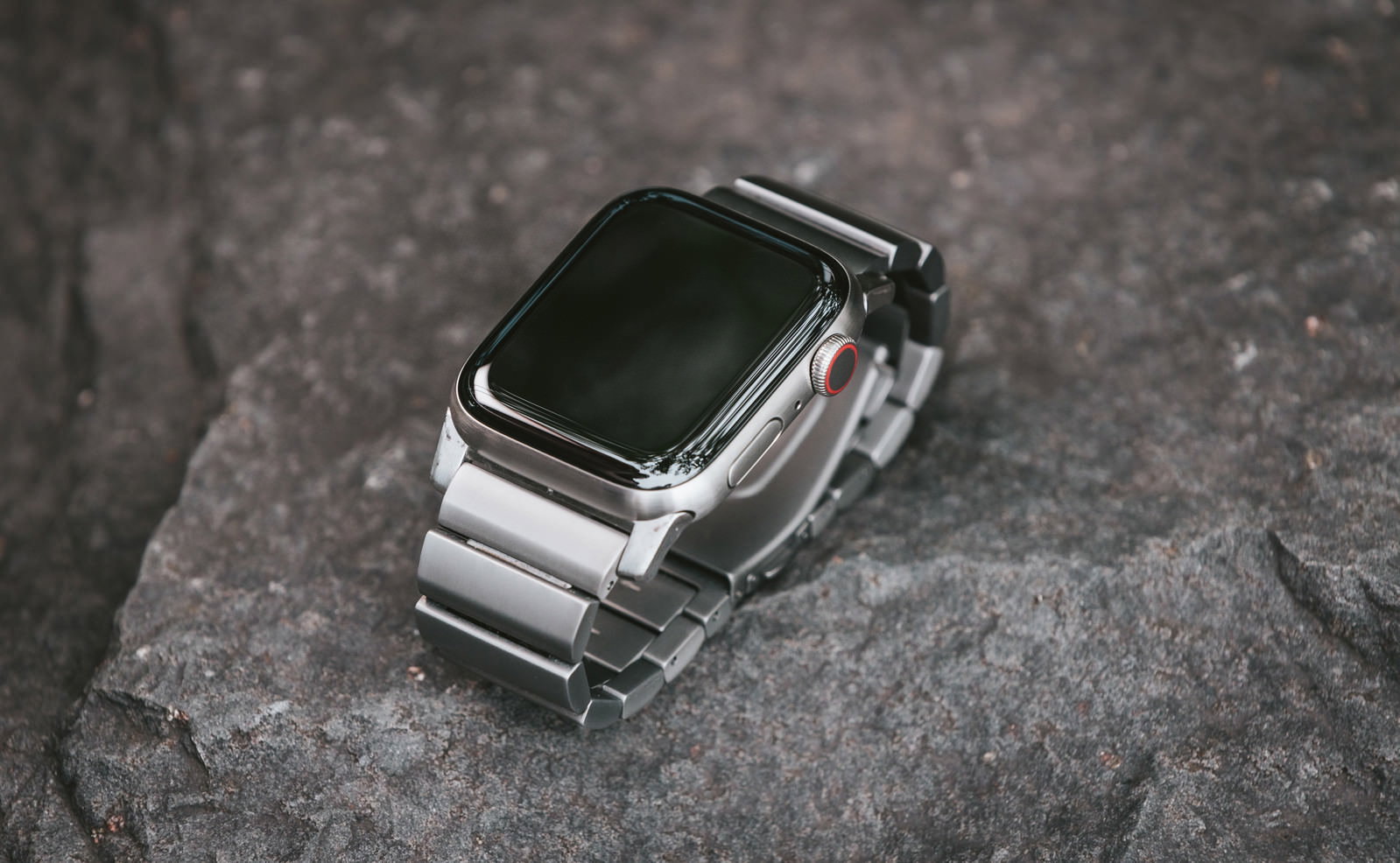 石の表面に置かれたメタルバンドのApple Watch