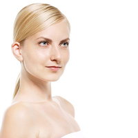 肩が見える金髪をまとめた女性の上半身の写真