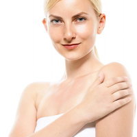 腕に触れながら微笑むロシア人女性のスキンケアの写真