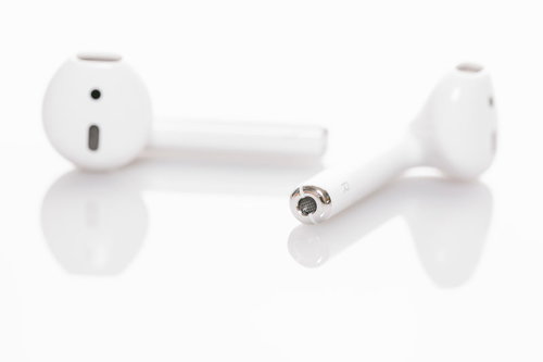 白基調のワイヤレスイヤホンと充電ケース、スマートフォンアクセサリー