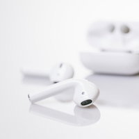 白いワイヤレスイヤホンと充電ケースの並べた一式の写真