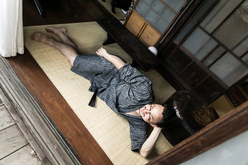 日本の夏を古民家の縁側で過ごす甚平姿の外国人男性