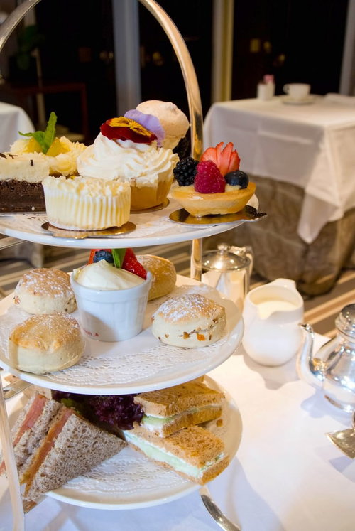 白い食器に並ぶスコーンとティーカップのアフタヌーンティー