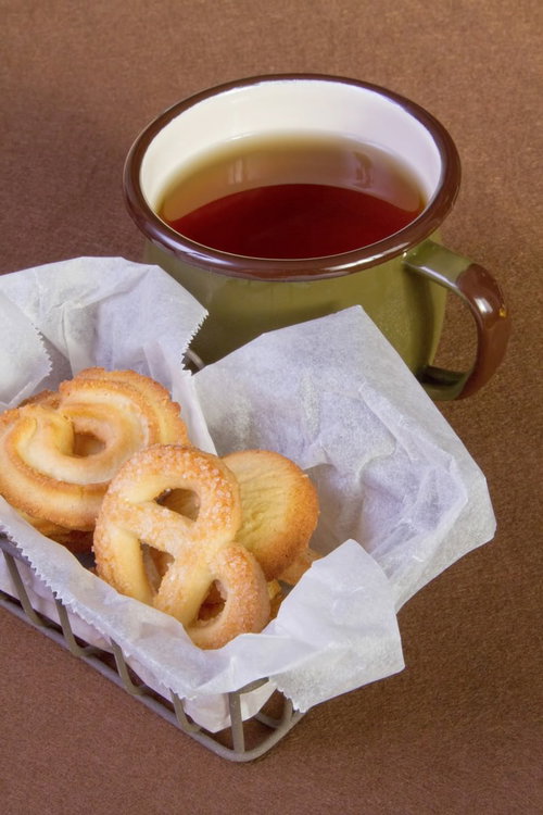 白い皿のクッキーとカップに注がれたお茶のティータイム