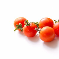 ヘタが付いたまま並ぶフレッシュなミニトマトの写真