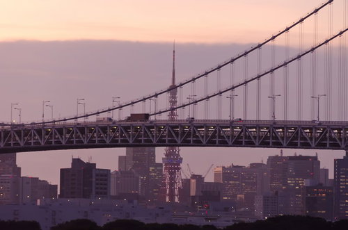 夕方のオレンジの空に東京タワーとレインボーブリッジが並ぶ風景