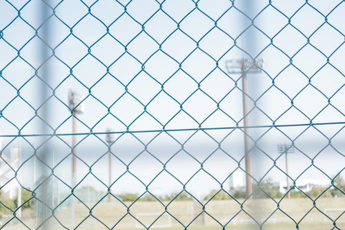 金網フェンス越しに見える野球場のグランド