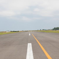 美唄スカイパークの滑走路と緑の草地、白黄色のセンターラインが引かれたアスファルトの写真