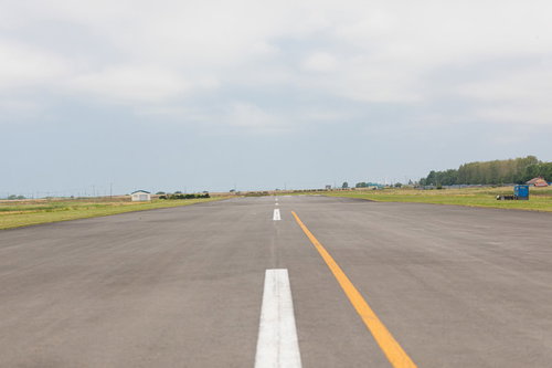 美唄スカイパークの滑走路と緑の草地、白黄色のセンターラインが引かれたアスファルト