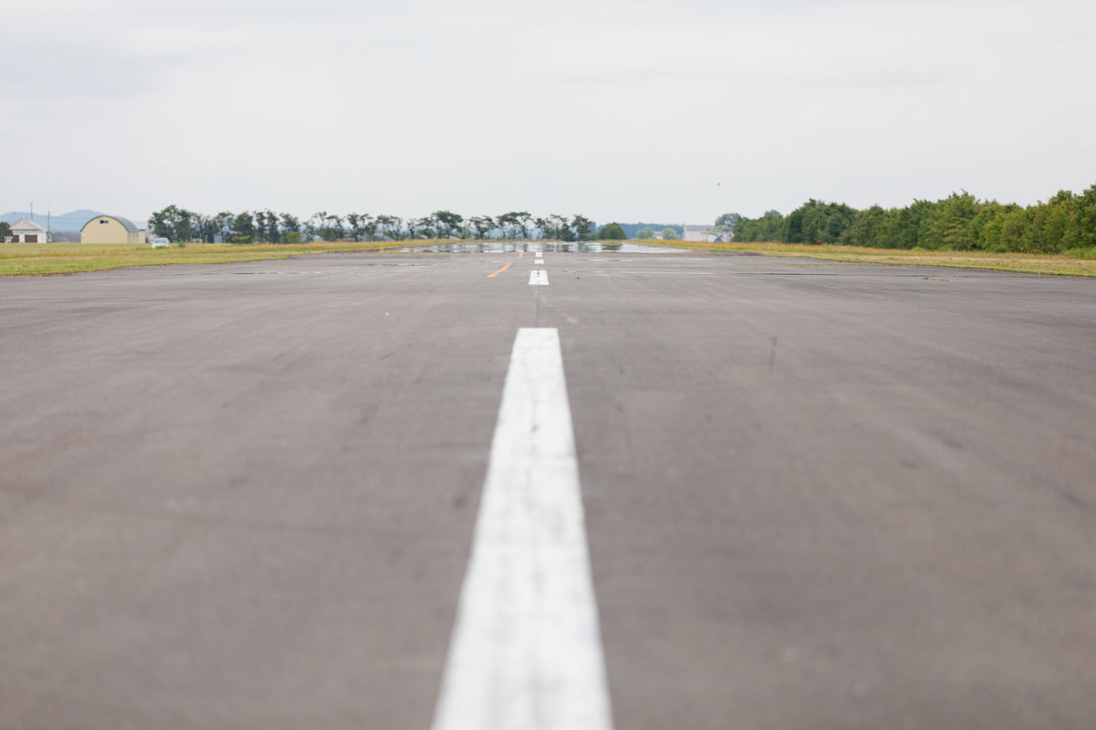 アスファルトの滑走路に白い中央線が引かれ、蜃気楼が立ち上がる様子