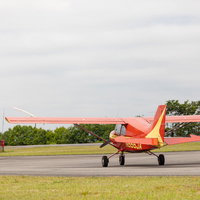 滑走路を走る赤と白の小型飛行機（美唄スカイパーク）の写真