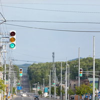 どこまでも続く青信号の信号機が立ち並ぶ道路の写真