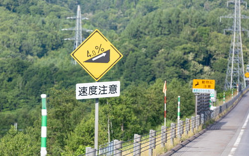 高速道路の傾斜4％標識と速度注意標識、山間部の急勾配区間