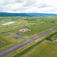 美唄市農道離着陸場の滑走路を空撮した田園風景の写真