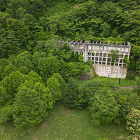 森林に囲まれた三菱美唄炭鉱原炭ポケットの空撮の写真