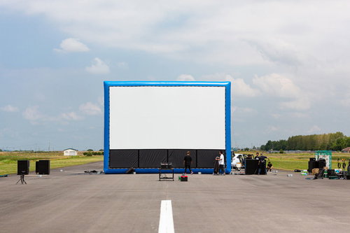 滑走路に設置された巨大スクリーンを準備するスタッフ
