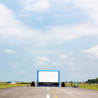 滑走路の上で野外映画用の巨大スクリーンを設営の写真