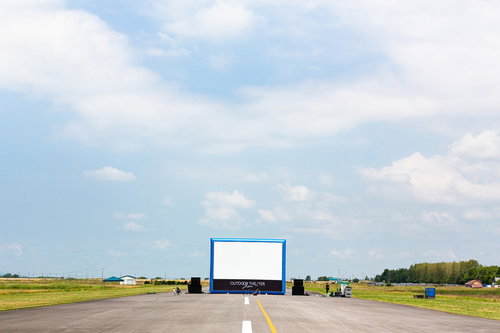 滑走路の上で野外映画用の巨大スクリーンを設営