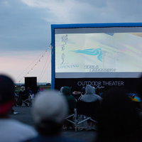 日が落ちてから上映がはじまる野外シネマの観客風景の写真