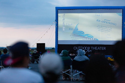 夜間の野外シネマで映画を鑑賞する観客たち