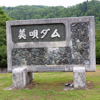 緑に囲まれた美唄ダムと書かれた石碑（北海道美唄市）の写真