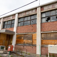 窓ガラスが割られ老朽化した美唄市我路郵便局の廃墟の写真