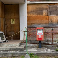 北海道美唄の我路郵便局の廃墟に残る赤い郵便ポストの写真