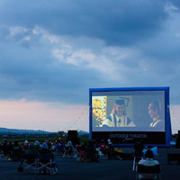 滑走路で開催される野外映画上映会と巨大スクリーンの写真