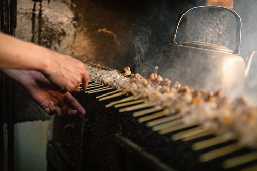 炭火でじっくり焼かれる美唄焼き鳥の串焼きの調理風景