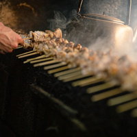 一度に何本もの鳥串を焼く美唄焼き鳥の老舗店での炭火調理の写真