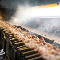 炭火でジューシーに焼き上げる美唄焼き鳥の串焼きの写真