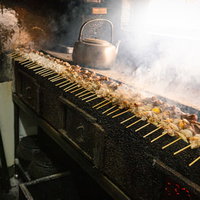 炭火台にずらりと並んだ美唄焼き鳥の串焼きの写真