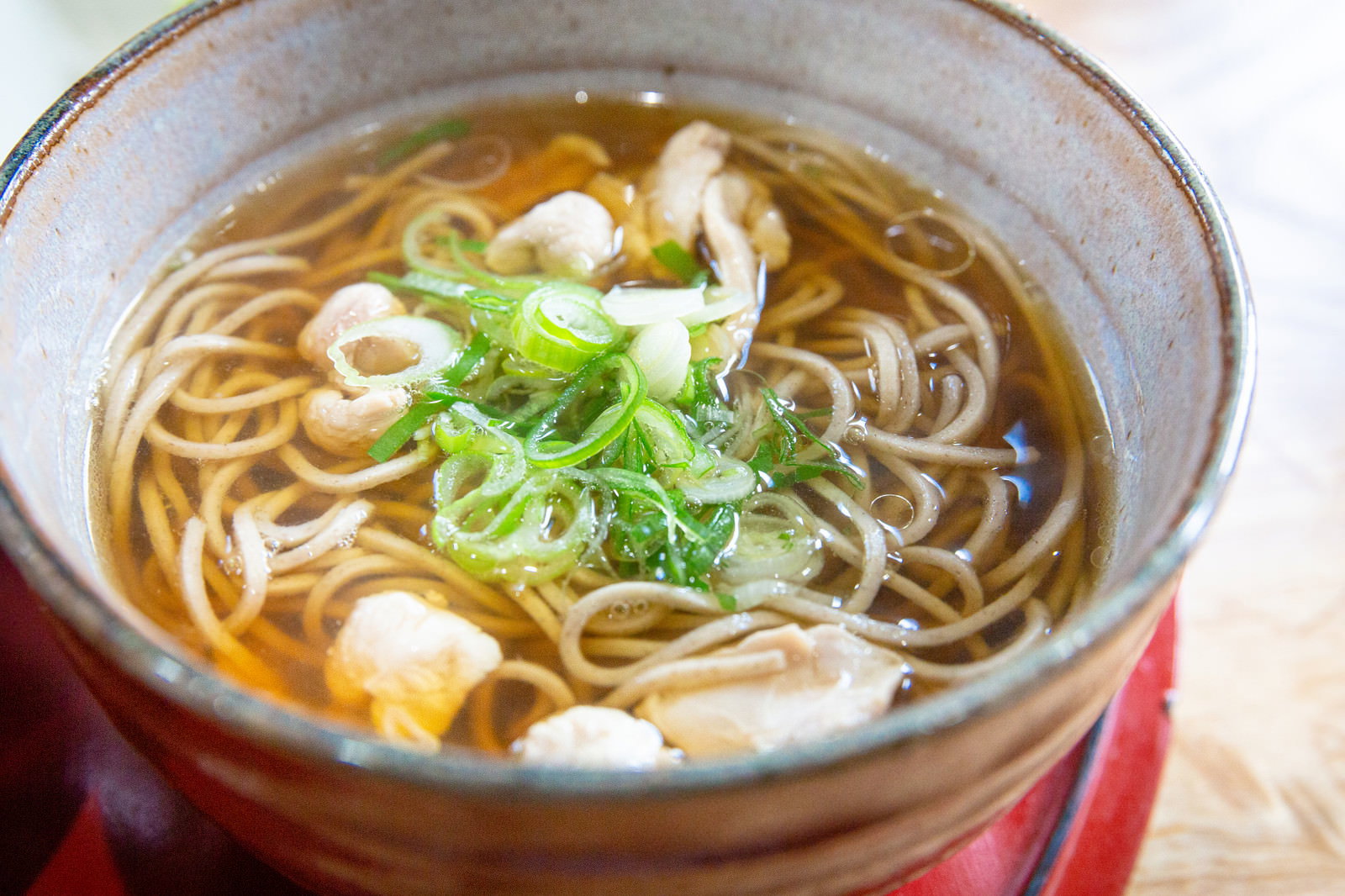 丼に盛られた鶏そば。透明なスープに蕎麦麺とネギが入っている