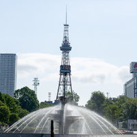 噴水越しに見るさっぽろテレビ塔の札幌の都市風景の写真