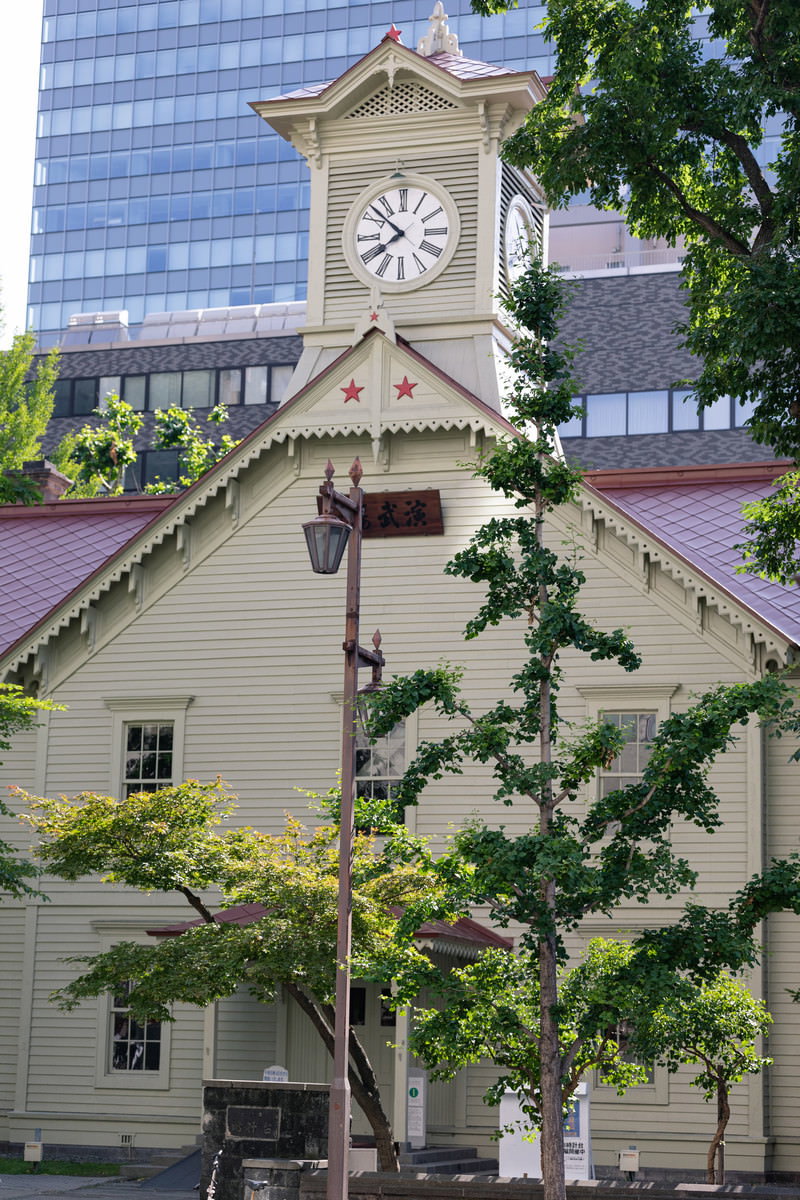 白い壁と赤い屋根の札幌市時計台、正面に時計が見える歴史的建造物