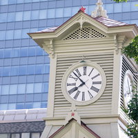時刻をしめす札幌市時計台（旧札幌農学校演舞場）の白い時計塔の写真