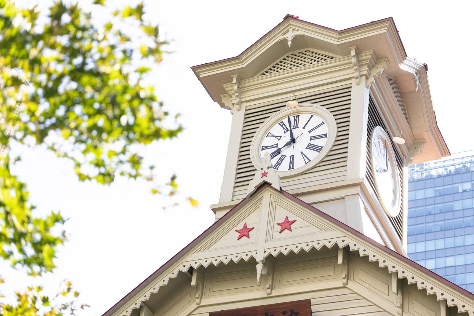 札幌市時計台の白い文字盤の時計と木造の屋根部分