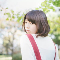 緑に囲まれた公園で振り返る美少女のポートレートの写真