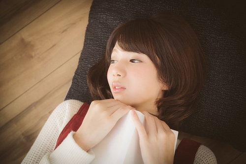 恋愛マンガで感傷に浸る美少女、本を抱きしめた姿