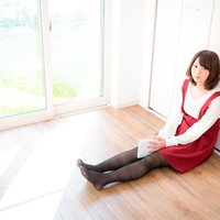 片付けで探していた漫画が出てきた時の女性の表情の写真