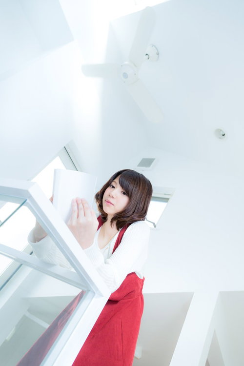 吹き抜けの新築でマンガを読む女性の読書風景