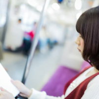 電車内でテスト範囲を暗記する黒髪の女学生の写真