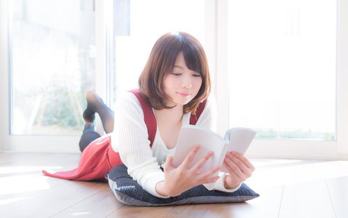 予想のつかない展開にワクワクしながら漫画を読む女性