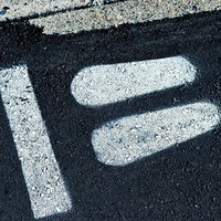 アスファルトに白いペンキで描かれた歩行者一時停止の標示の写真