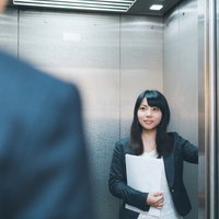 「何階ですか？」と来客に尋ねる気が利く社員の写真