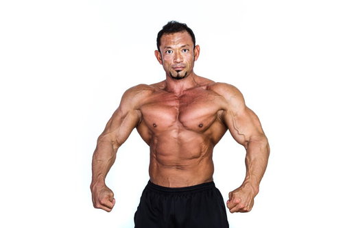 肉体美を披露するボディビルダー男性の筋肉質な上半身ポーズ