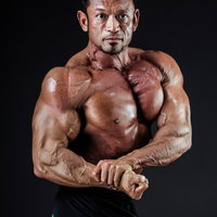 サイドチェストで筋肉を見せるボディビルダー男性の写真